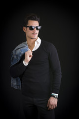 Attractive, trendy young man with black sweater and sunglasses