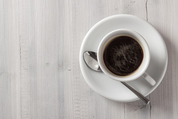 Cup of coffee from above on white wooden table
