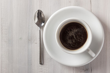 Cup of coffee from above on white wooden table