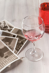 Memories. Bottle of rose wine, wine glass and old photos