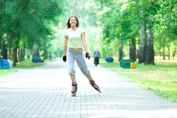 Roller skating sporty girl in park rollerblading on inline skate