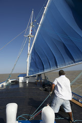 Brazilian Sailboat with Blue Sails in Turbulent Waters