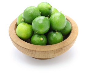 fresh key limes in wooden bowl
