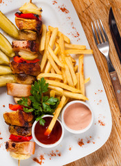 Chips and skewers on a white plate