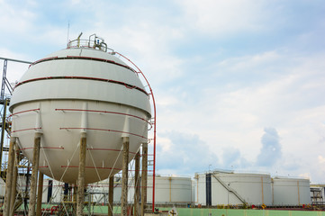 Natural Gas Tank and row of large white tanks for petrol and oil