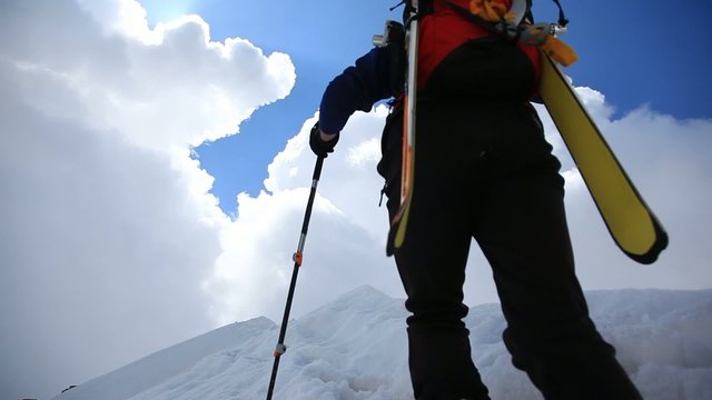 Ski mountaineer walking up along a steep snowy ridge