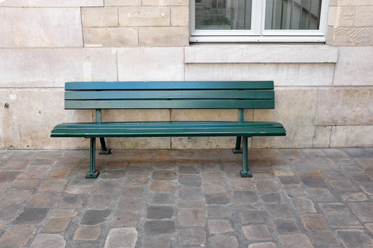 banc vert dans la cour au solpav&eacute;
