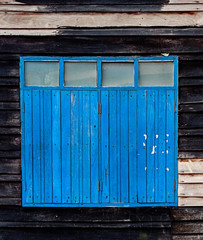 Old Blue Window on Weathered Wooden Wall