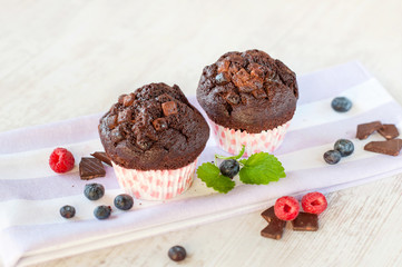 Two delicious homemade chocolate muffins in colored cooking pape