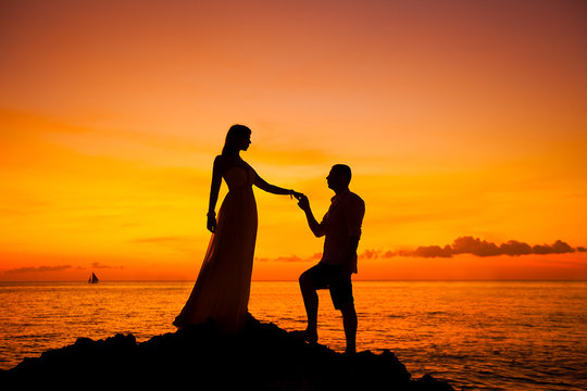bride and groom on a tropical beach with the sunset in the backg