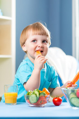 kid boy eating healthy food at home interior