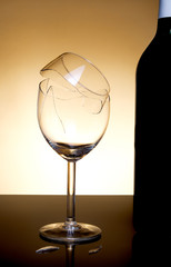 Vine bottle and broken glass on orange background