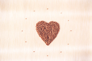 Heart shaped buckwheat cereals on a beige linen serviette