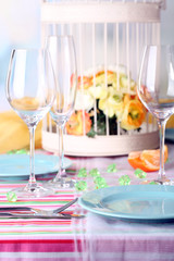 Table serving with colorful tableware on room background