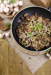 Delicious fried mushrooms in pan on table close-up