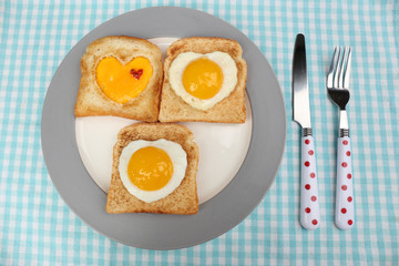 Scrambled eggs with bread on plate, on color napkin