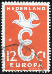 stamp printed in Netherlands, shows a stylized dove and letter E
