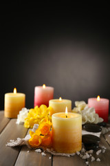 Beautiful candles with flowers on wooden background