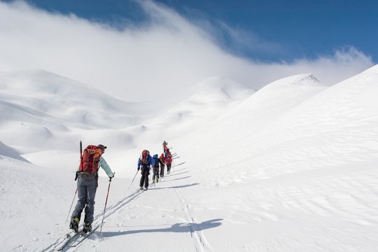 Skiers walking towards mountains