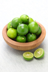 fresh key limes in wooden bowl