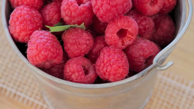 Ripe raspberry in zinc bucket, turn, video