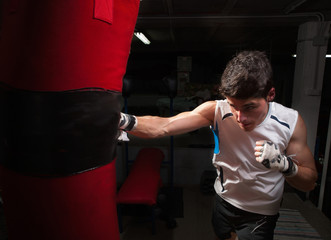 Young caucasian Boxer training with a punching bag
