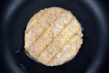 Vegetable burger patty cooking in skillet