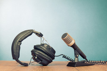 Microphone and headphones on table front mint green background