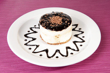 Sweet cake with chocolate on plate on table close-up