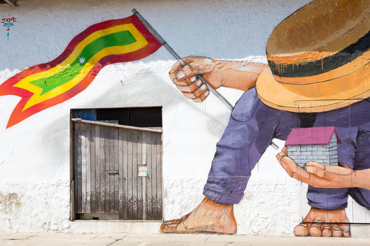 Man with hat and house and a Colombian flag in his hands
