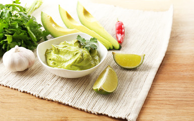 Fresh guacamole in bowl on table