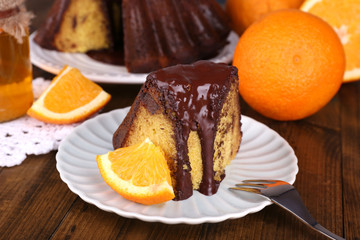 Piece of delicious cake  with oranges on table close-up