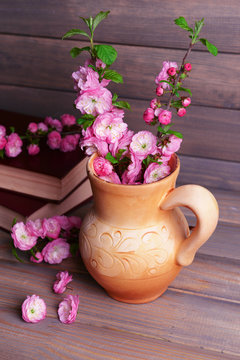 Beautiful fruit blossom in pitcher on table on grey background