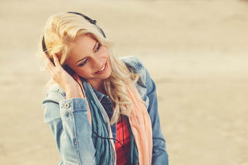 Beautiful blonde with headphones listening to music