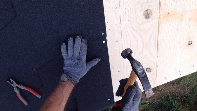 dachdecker mit werkzeug auf einem Dach