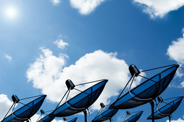 black antenna communication satellite dish on blue sky