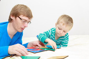 father and son playing with puzzle