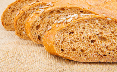 Pieces of bread with seeds on burlap, food photo