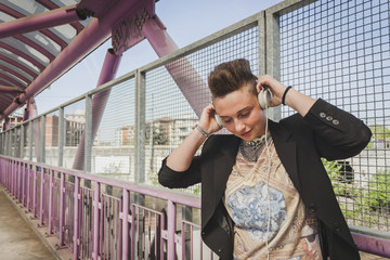 Pretty short hair girl listening to music on a bridge