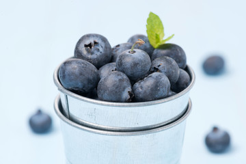 Fresh blueberries in a metal bucket, selective focus