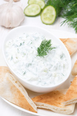 yoghurt sauce tzatziki with pieces of pita bread, top view
