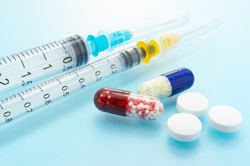 Medicines and syringes on blue background. Clean medicine image.
