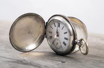 Old pocket-watch on wooden background