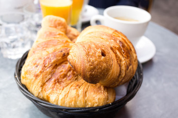 Breakfast with coffee and croissants in a basket