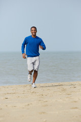 Healthy young man jogging at the beach