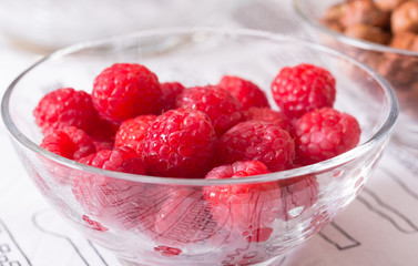raspberries and hazelnuts in glass bowls