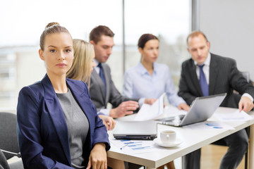 businesswoman in office with team on the back