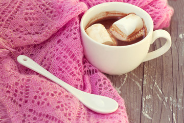 cup of hot chocolate wrapped in a scarf