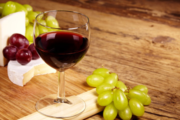 A red glass of wine and cheese