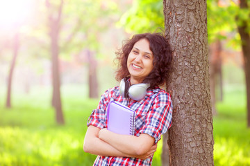 Indian girl with headphones in the park.